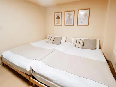 a large white bed in a room with pictures on the wall at I HOUSE jujo in Tokyo