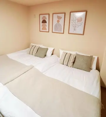 two beds in a room with white sheets and pillows at I HOUSE jujo in Tokyo