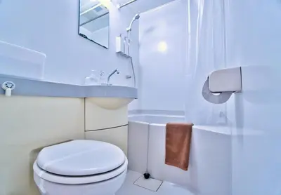 a white bathroom with a toilet and a sink at I HOUSE jujo in Tokyo