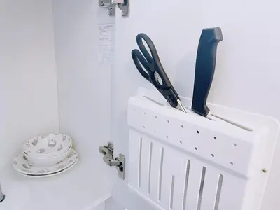 a white knife holder with some knives and a plate at ksi\u5357\u5e38\u76e4\u53f0402 in Tokyo
