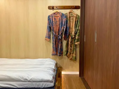a robe hanging on a wall next to a bed at TOKYO SKYTREE HOUSE-Multiple room styles in Tokyo