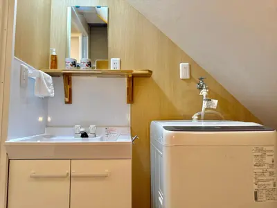 a small bathroom with a sink and a washing machine at TOKYO SKYTREE HOUSE-Multiple room styles in Tokyo