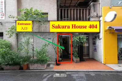 a building with a yellow and red sign on it at 50 \u5e73\u65b9 - \u65b0\u5bbf 1 \u7ad9\u5730 - \u65b0\u5927\u4e45\u4fdd\u7ad9 4 Min - \u6b4c\u821e\u4f0e\u753a 4 Min - Sakura 404 in Tokyo