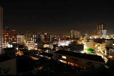 a view of a city at night with lights at 50 \u5e73\u65b9 - \u65b0\u5bbf 1 \u7ad9\u5730 - \u65b0\u5927\u4e45\u4fdd\u7ad9 4 Min - \u6b4c\u821e\u4f0e\u753a 4 Min - Sakura 404 in Tokyo