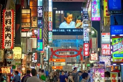 a crowd of people in a busy city with signs at 50 \u5e73\u65b9 - \u65b0\u5bbf 1 \u7ad9\u5730 - \u65b0\u5927\u4e45\u4fdd\u7ad9 4 Min - \u6b4c\u821e\u4f0e\u753a 4 Min - Sakura 404 in Tokyo