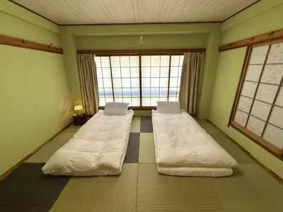 two beds in a room with a large window at TOKYO SKYTREE VILLIA-Whole villia space perfect for families and groups in Tokyo