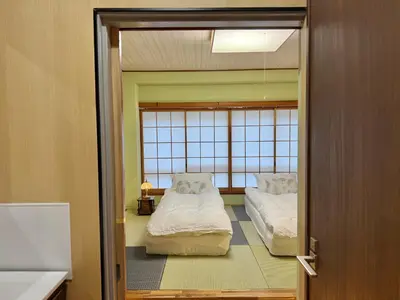 a room with two beds and a door open at TOKYO SKYTREE VILLIA-Whole villia space perfect for families and groups in Tokyo