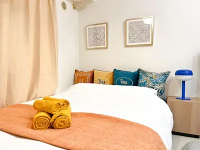 a bedroom with a bed with yellow towels on it at Stylish ROCO house Omori8min in Tokyo
