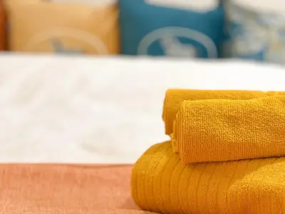 a stack of yellow towels sitting on a table at Stylish ROCO house Omori8min in Tokyo