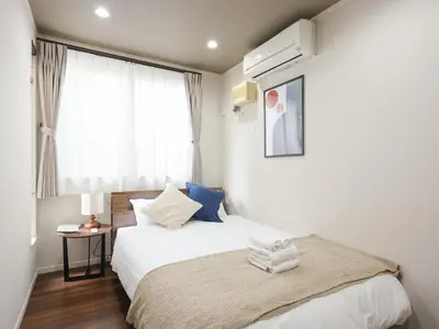 a bedroom with a bed and a window at \u30bc\u30a6\u30b9\u6c60\u4e0a Zeus Ikegami in Tokyo