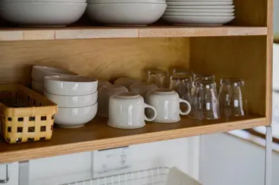 a shelf with dishes and mugs on it at Cube Sangenjaya in Tokyo