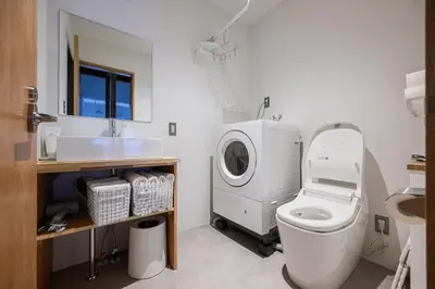 a bathroom with a washing machine and a toilet at Cube Sangenjaya in Tokyo