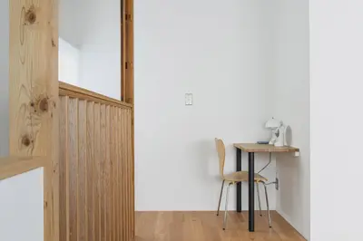 a table and chair in a room with a white wall at Cube Sangenjaya in Tokyo