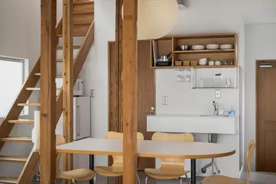 a kitchen and dining room with a table and stairs at Cube Sangenjaya in Tokyo