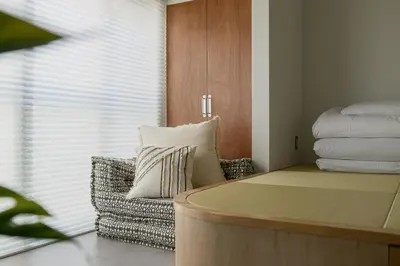 a room with a couch and a pillow and a window at Cube Sangenjaya in Tokyo