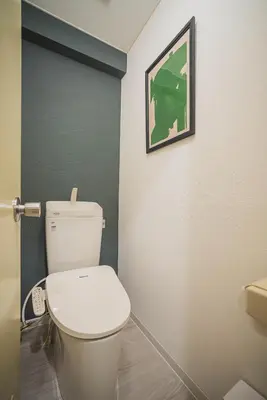 a bathroom with a toilet and a picture on the wall at 2 Minutes Walk to Ikebukuro Station, Modern Stay, Very Convenient in Tokyo