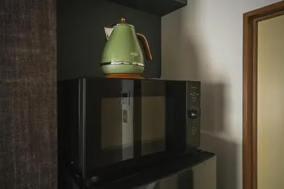 a green tea pot sitting on top of a microwave at 2 Minutes Walk to Ikebukuro Station, Modern Stay, Very Convenient in Tokyo