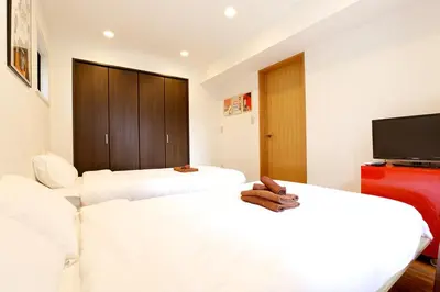 a hotel room with two beds and a flat screen tv at Taishido House in Tokyo