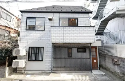 a white brick house with a gate in front of it at Taishido House in Tokyo
