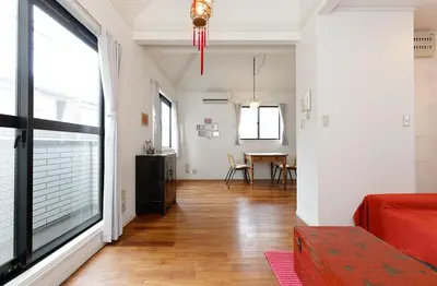 a living room with a red couch and a table at Taishido House in Tokyo