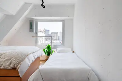two beds in a white room with a window at Casa di Luce - Stylish Stay near Shibuya & Meguro River Room405 in Tokyo