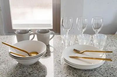 a table with plates and forks and wine glasses at Casa di Luce - Stylish Stay near Shibuya & Meguro River Room405 in Tokyo