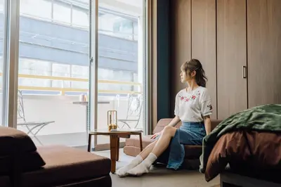 a woman sitting in a chair in a room at Villa Boushu KURAMAE in Tokyo