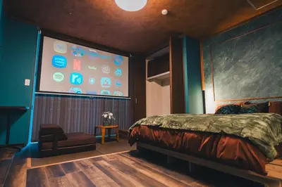 a bedroom with a large screen with a bed and a chair at Villa Boushu KURAMAE in Tokyo