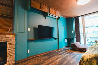 a bedroom with a blue wall with a flat screen tv at Villa Boushu KURAMAE in Tokyo