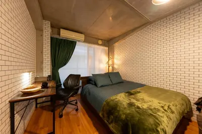 a bedroom with a bed and a desk and a window at Villa Boushu KURAMAE in Tokyo