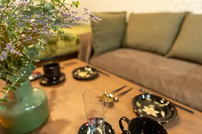 a coffee table with a vase of flowers and a couch at Villa Boushu KURAMAE in Tokyo