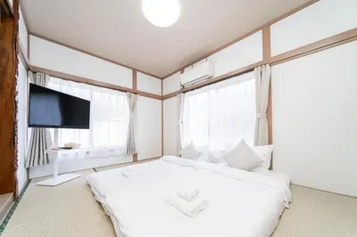 a bedroom with a white bed and a flat screen tv at \u938c\u5009\u56db\u4e01\u76ee in Tokyo