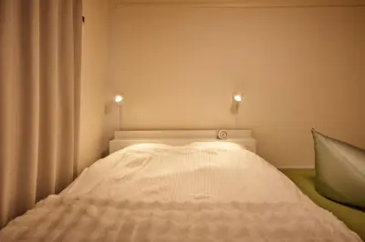 a bed in a room with two lights on the wall at Tokyo Retreat -SUMIDA- in Tokyo