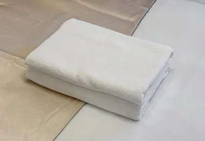 a stack of white towels sitting on a table at Higashi-Shinjuku 1001 in Tokyo