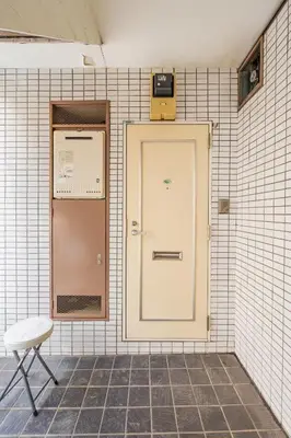 a door and a chair in a tiled wall at \u65b0\u5bbf\u5f92\u6b69\u570f\u306e\u30db\u30c6\u30eb\u897f\u65b0\u5bbf\u4e94\u4e01\u76ee\u99c52\u5206 in Tokyo