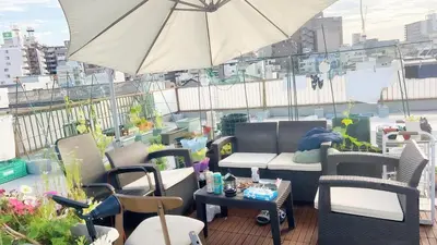 a balcony with chairs and tables and an umbrella at \u70df\u96e8\u8f69301\u65b0 in Tokyo