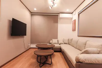 a living room with a couch and a flat screen tv at \u548c\u6c23\u4f1a\u3005\u6e0b\u8c37\u672c\u753a Wakiaiai Shibuyahontyo in Tokyo