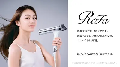 a woman holding a hair dryer next to a picture at Villa Sumida Five in Tokyo