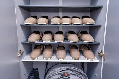 a row of brown shoes on shelves in a closet at Villa Sumida Five in Tokyo