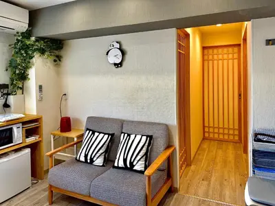 a living room with a couch and a clock on the wall at 32B Ikebukuro, 3 bedrooms and 1 living room, 7 mins to ST Max 7P \u6c60\u888b \u5168\u65b0\u88c5\u4fee \u4e09\u5ba4\u4e00\u5385 \u4ea4\u901a\u4e2d\u5fc3 \u8f66\u7ad97\u5206\u949f \u6700\u59277\u4eba \u76f4\u8fbe\u65b0\u5bbf \u6d89\u8c37 \u8868\u53c2\u9053 \u54c1\u5ddd \u6c60\u888b \u4e0a\u91ce \u4ee3\u4ee3\u6728 \u94f6\u5ea7 \u539f\u5bbf in Tokyo