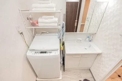 a white bathroom with a sink and a mirror at \u83ef\u590f\u6c11\u5bbf in Tokyo