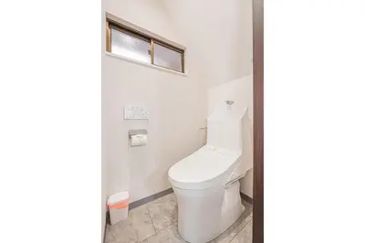 a white toilet in a bathroom with a window at \u83ef\u590f\u6c11\u5bbf in Tokyo