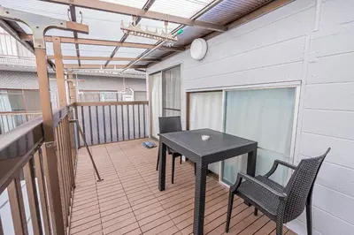 a patio with a table and chairs on a balcony at \u83ef\u590f\u6c11\u5bbf in Tokyo