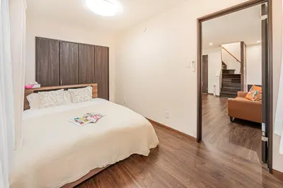 a bedroom with a large white bed and a couch at \u83ef\u590f\u6c11\u5bbf in Tokyo