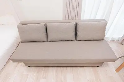 a couch sitting in a living room next to a window at 67 Apartment Ueno in Tokyo