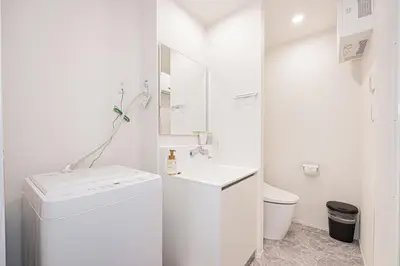 a white bathroom with a sink and a toilet at 67 Apartment Ueno in Tokyo