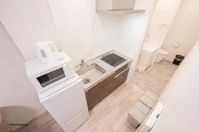 a small kitchen with a sink and a microwave at 67 Apartment Ueno in Tokyo