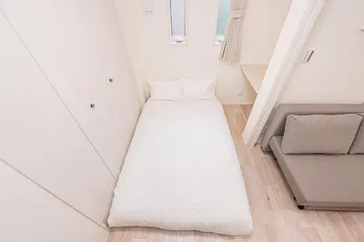 a small room with a bed and a couch at 67 Apartment Ueno in Tokyo