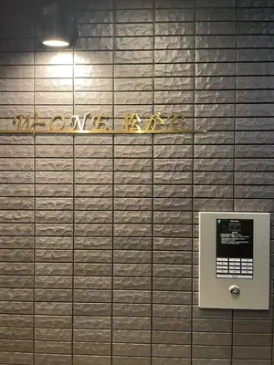 a sign on a tiled wall with a urinal at 67 Apartment Ueno in Tokyo