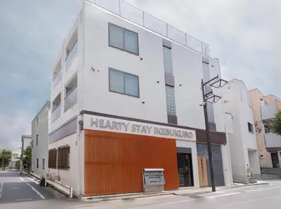 a white building with a sign that reads healthy stay hospitalized at Hearty Stay Ikebukuro in Tokyo